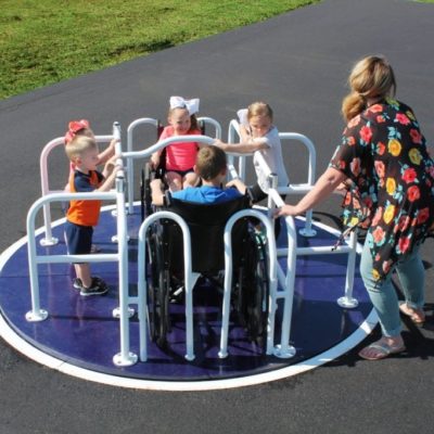 kids playing on wheelchair accessible merry go round