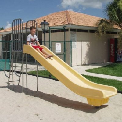 Child sliding down a slide in yellow